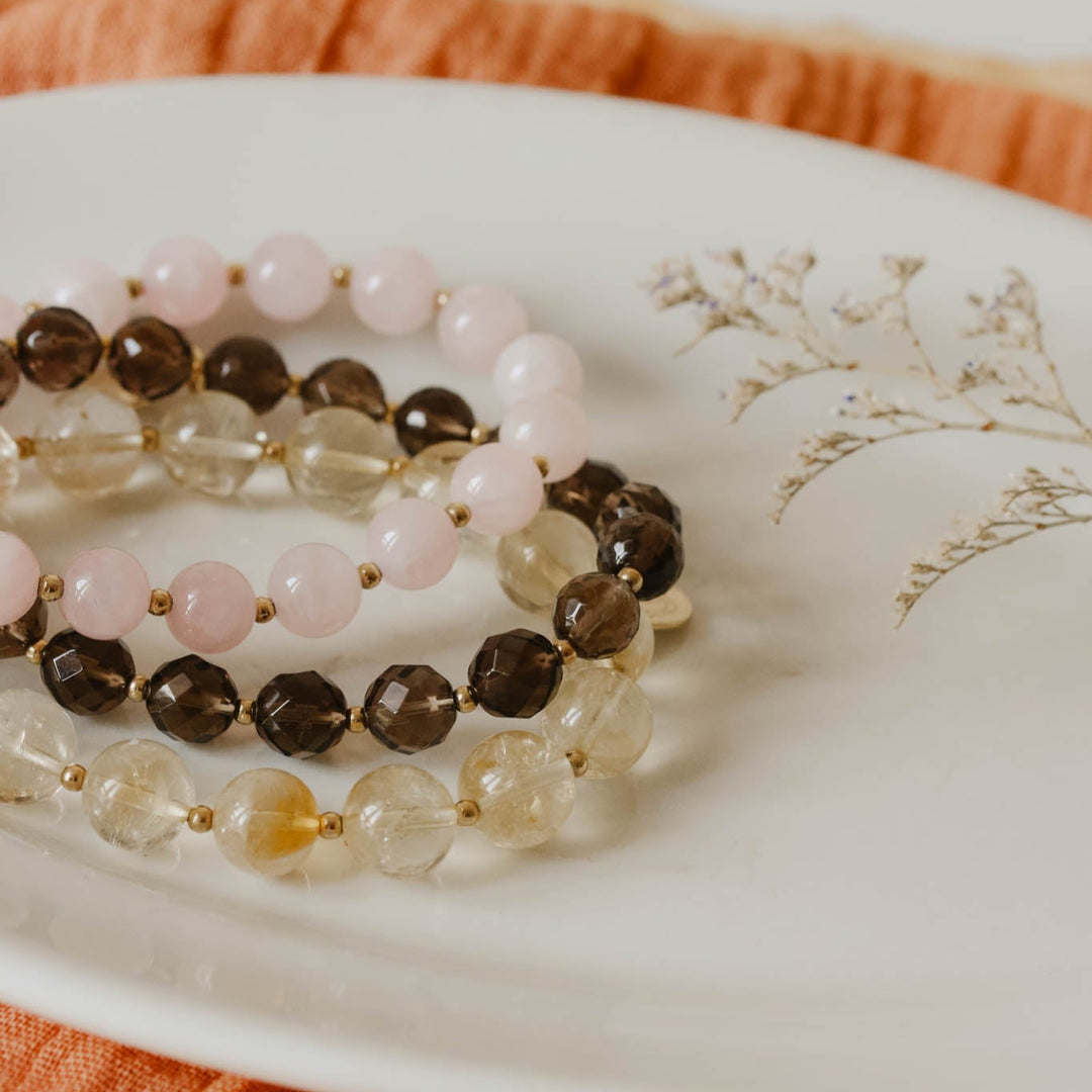 Set of beaded bracelets on a decorative plate with an orange fabric background