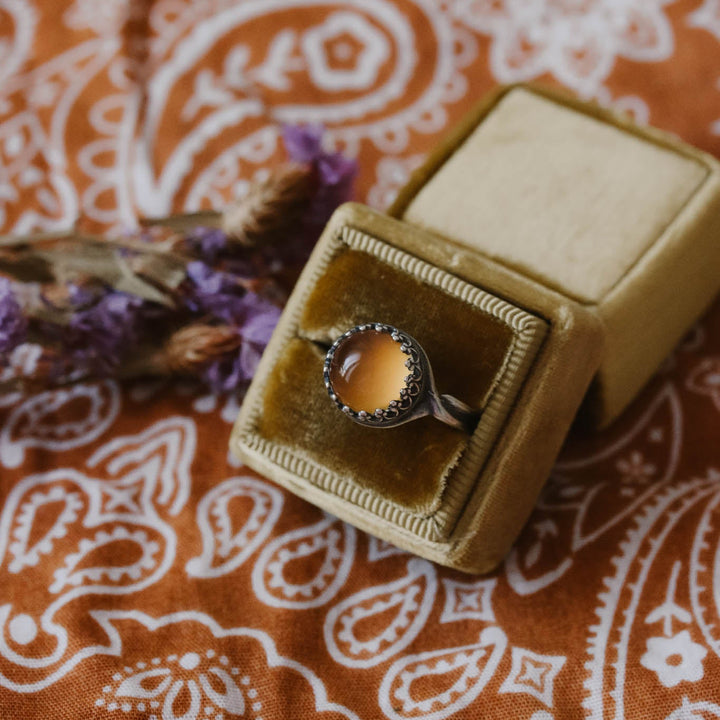 Ring in a velvet box on a patterned fabric background