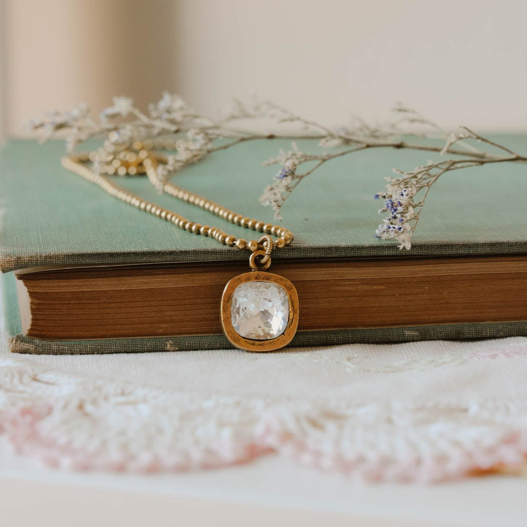 Gold necklace with a pendant on a vintage book